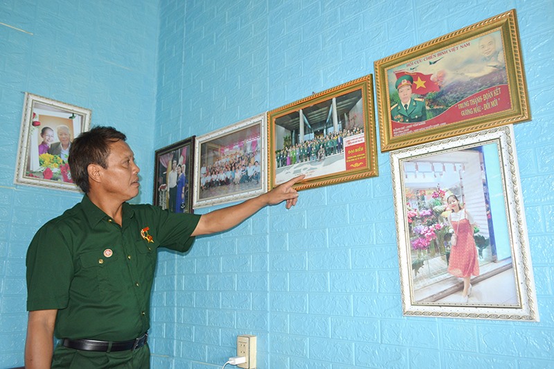 Cựu chiến binh Ngô Văn Minh kể về đồng chí, đồng đội trong bức ảnh chụp chung khi dự cuộc gặp mặt kỷ niệm 40 năm Cuộc chiến đấu bảo vệ biên giới phía Bắc được tổ chức tại Hà Nội năm 2019 - Ảnh: Đ.V