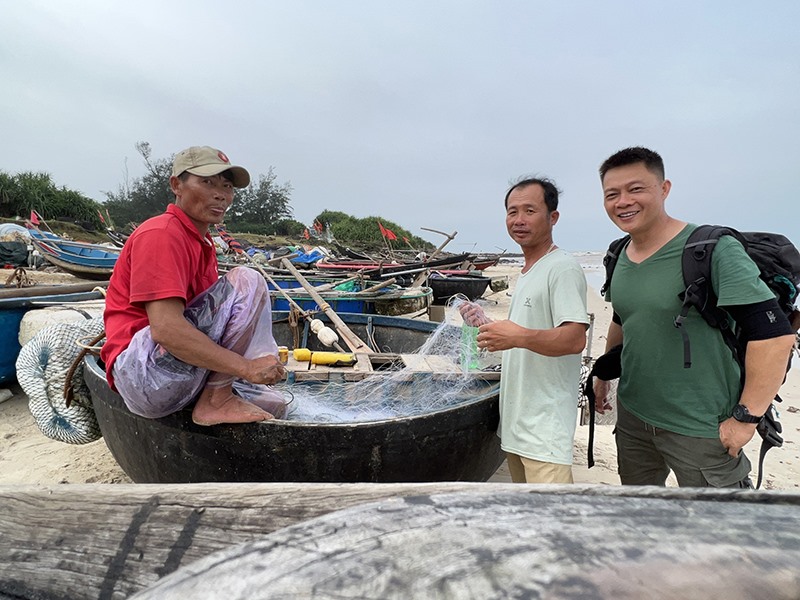 Nhà báo Trần Quang Minh trò chuyện với người dân Quảng Trị trên hành trình tác nghiệp - Ảnh: NVCC