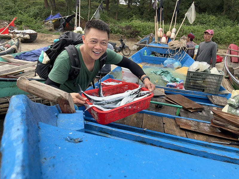 Nhà báo Trần Quang Minh chia vui cùng ngư dân xã Vịnh Mốc sau chuyến ra khơi - Ảnh:NVCC