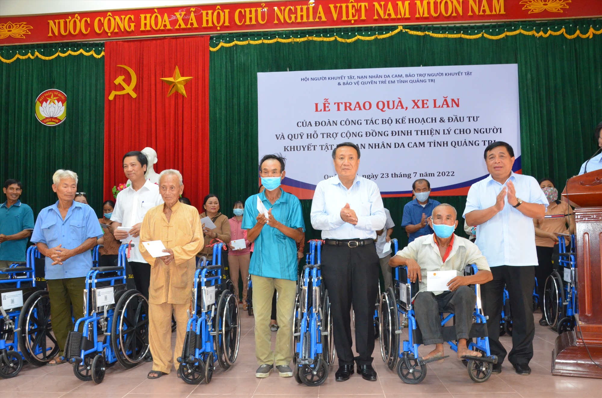 Bộ trưởng Bộ Kế hoạch & Đầu tư Nguyễn Chí Dũng và lãnh đạo tỉnh trao tặng xe lăn cho người khuyết tật và nạn nhân dan cam - Ảnh: Lê Minh
