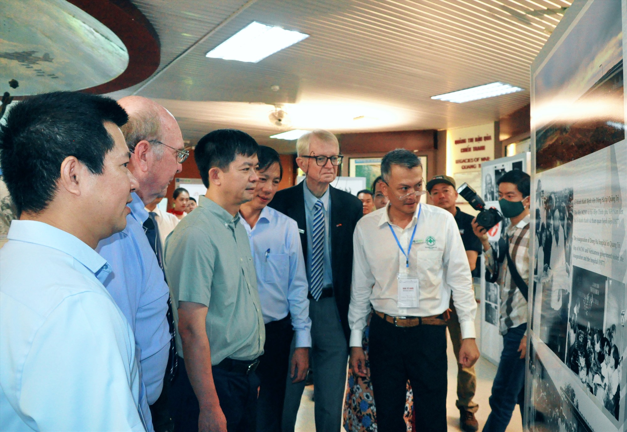 Bí thư Tỉnh ủy Lê Quang Tùng, Phó Chủ tịch UBND tỉnh Hoàng Nam và đại diện các tổ chức, dự án xem những bức ảnh tại triển lãm “Quảng Trị - Điểm đến của ký ức” - Ảnh: Q.H