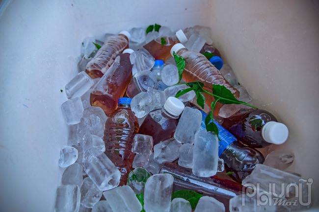 Những chai nước chè xanh ướp lạnh chuẩn bị phát miễn phí cho người đi đường giải khát.