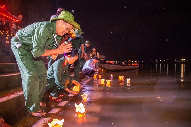 Các cựu chiến binh thả hoa đăng tưởng nhớ đồng đội trên sông Thạch Hãn -Ảnh: Hoàng Táo