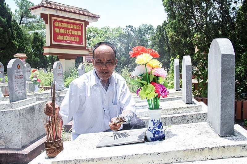 Ông Thành luôn chăm sóc chu đáo các phần mộ, thắp hương tri ân các anh hùng liệt sĩ tại Nghĩa trang liệt sĩ xã Hải Thượng, Hải Lăng - Ảnh: M.Đ
