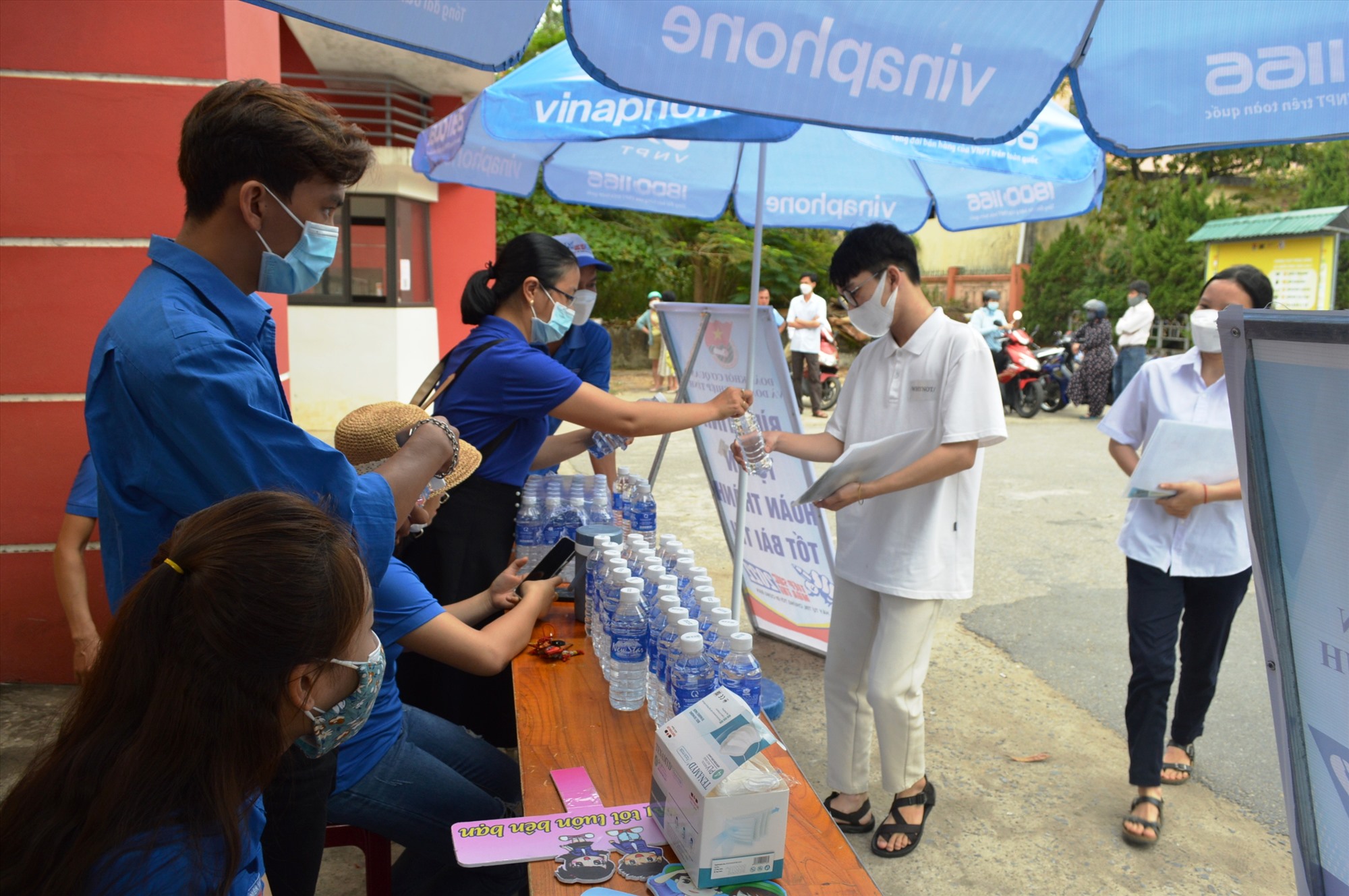 Đội ngũ tình nguyện viên hỗ trợ nước uống cho thí sinh trước khi các em bước vào phòng thi - Ảnh: ĐV