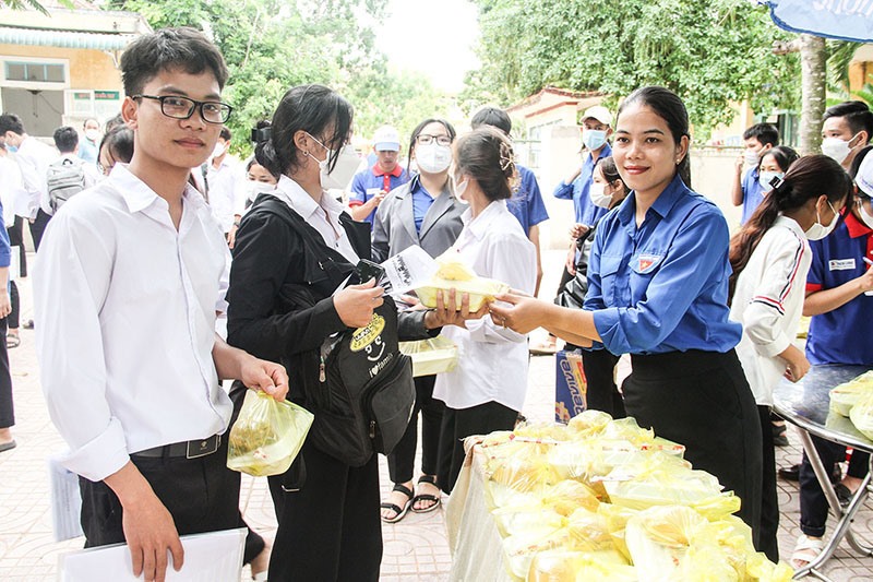 Thí sinh xúc động nhận suất cơm hỗ trợ từ tình nguyện viên tiếp sức mùa thi ở huyện Đakrông - Ảnh: M.Đ