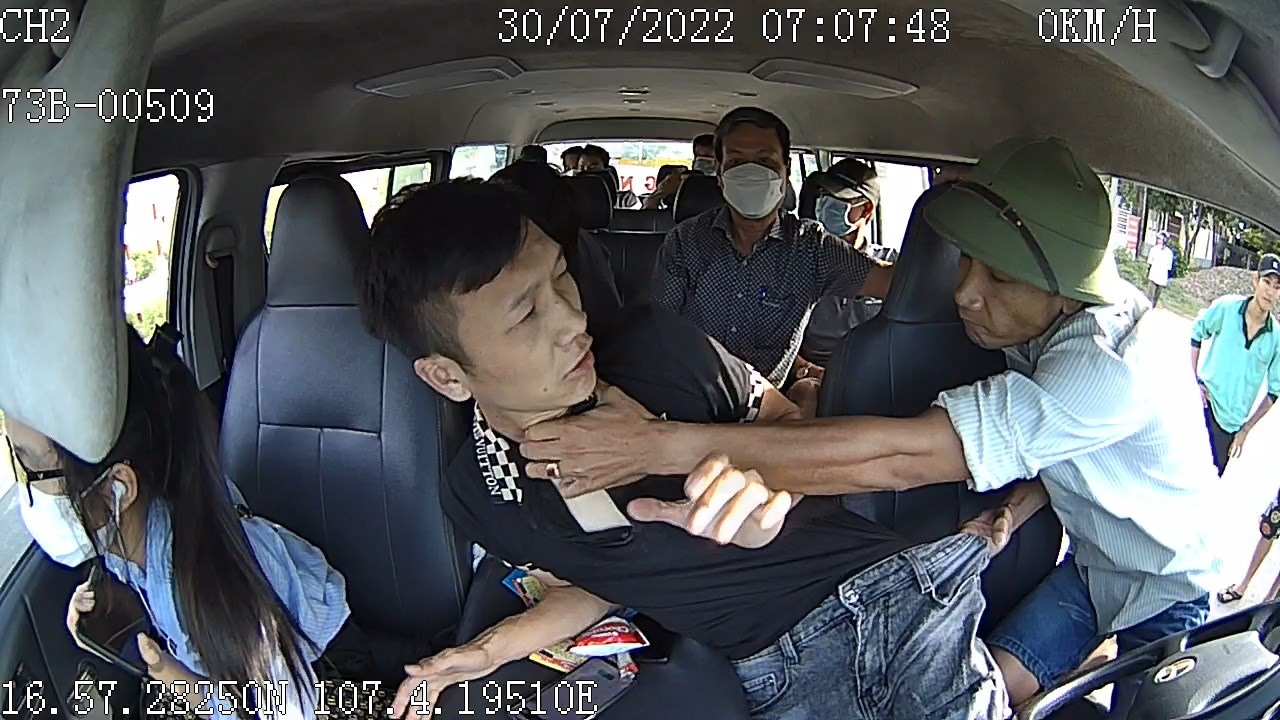 Tài xế Nguyễn Viết Lương (áo đen) bị các đối tượng hành hung trên xe - Ảnh: Cắt từ clip
