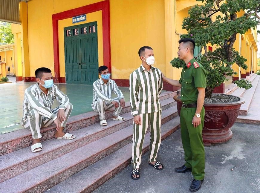 Cán bộ trại giam Ninh Khánh động viên phạm nhân T.M.C được đề nghị đặc xá năm 2022. (Ảnh: TTXVN)