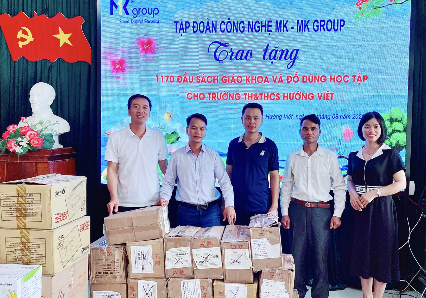 Lãnh đạo xã Hướng Việt trao sách và đồ dùng học tập của Tập đoàn Công nghệ MK cho Trường Tiểu học và THCS Hướng Việt  - Ảnh: Tú Linh