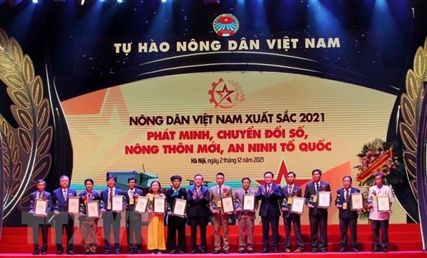 Chủ tịch Quốc hội Vương Đình Huệ và Chủ tịch Hội Nông dân Việt Nam Lương Quốc Đoàn trao giải thưởng cho nhóm nông dân thuộc lĩnh vực phát minh, chuyển đổi số, nông thôn mới, an ninh tổ quốc năm 2021. (Ảnh: Tuấn Đức/TTXVN)