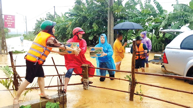 Vận chuyển hàng hóa thiết yếu hỗ trợ bà con xã Cam Tuyền, huyện Cam Lộ trong lũ lụt - Ảnh: M.T