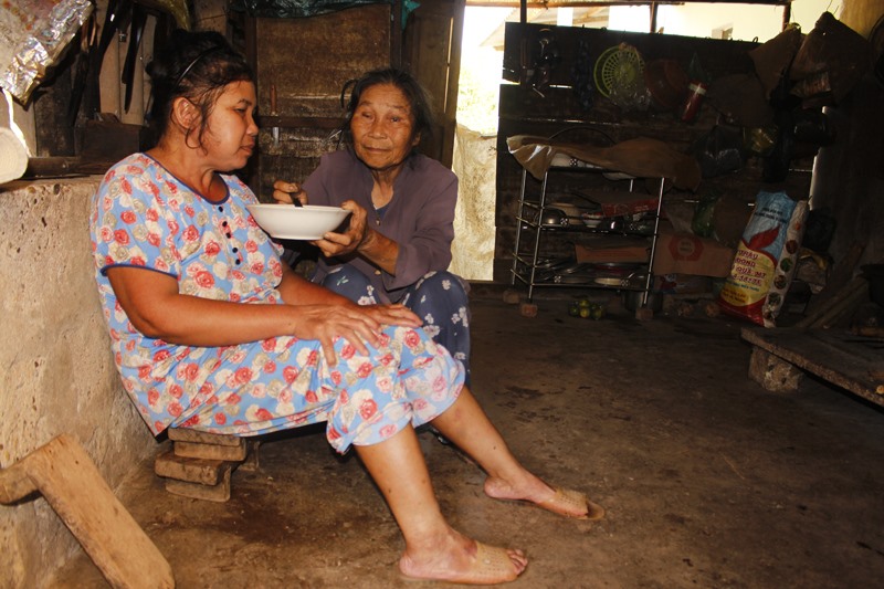 Bà Hồ Thị Gẩm chăm sóc người con gái mù lòa, bệnh tật - Ảnh: H.T