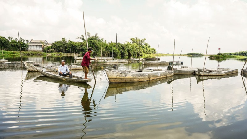 Người dân thôn Văn Trị, xã Hải Phong kiểm tra các lồng nuôi cá chình trước mùa mưa bão - Ảnh: L.A