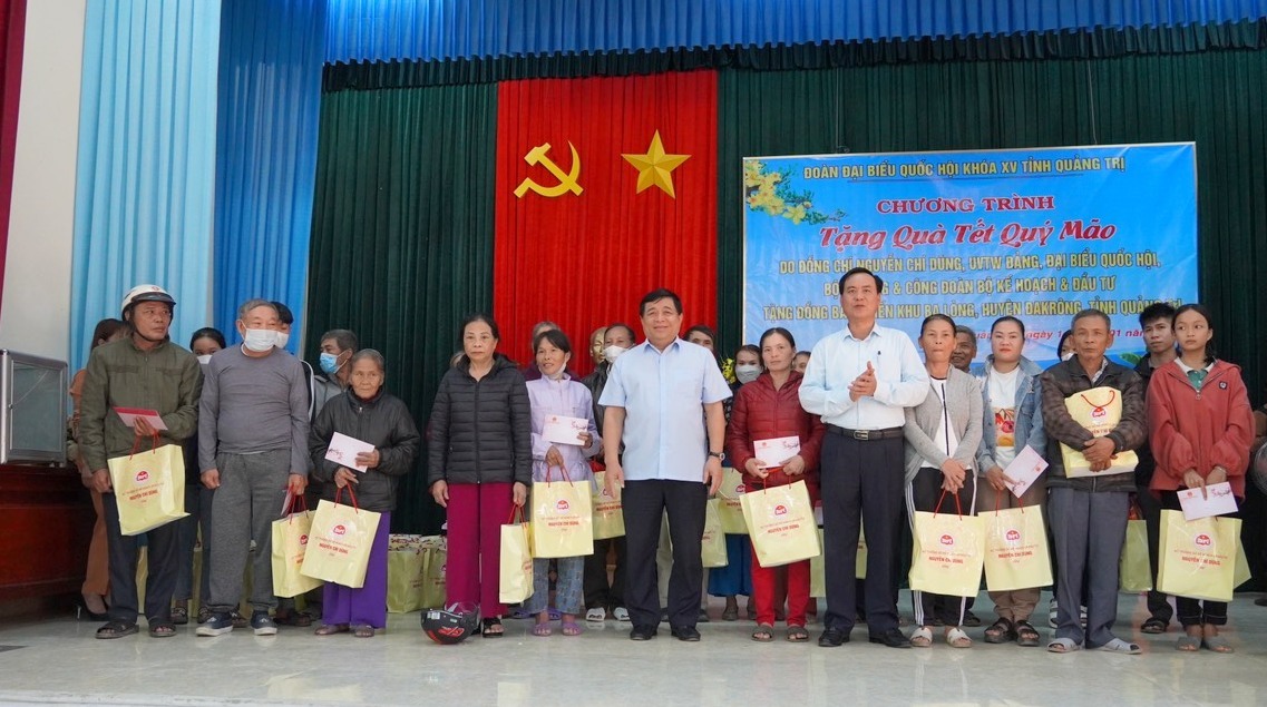 Bộ trưởng Bộ KH&ĐT Nguyễn Chí Dũng và Chủ tịch UBND tỉnh Võ Văn Hưng tặng quà cho các đối tượng chính sách tại xã Ba Lòng - Ảnh: M.Đ