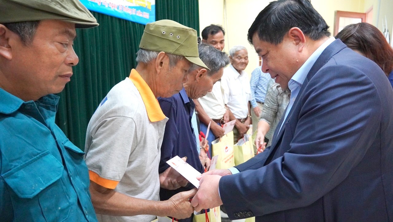 Bộ trưởng Bộ KH&ĐT Nguyễn Chí Dũng tặng quà cho gia đình cách mạng ở xã Linh Trường - Ảnh: M.Đ