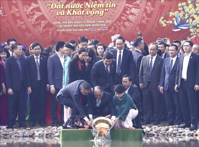 Chủ tịch nước Nguyễn Xuân Phúc và Phu nhân cùng các đại biểu kiều bào thả cá chép tiễn ông Công, ông Táo theo phong tục truyền thống. Ảnh: TTXVN