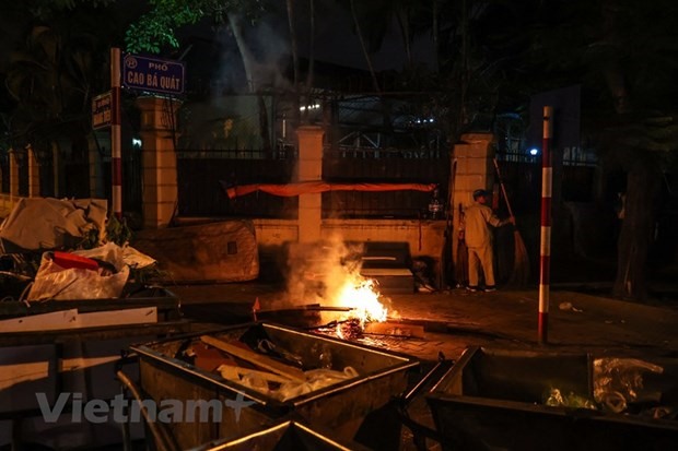 Người dân Hà Nội đốt lửa sưởi ấm trong đêm. (Ảnh: Minh Sơn/Vietnam+)