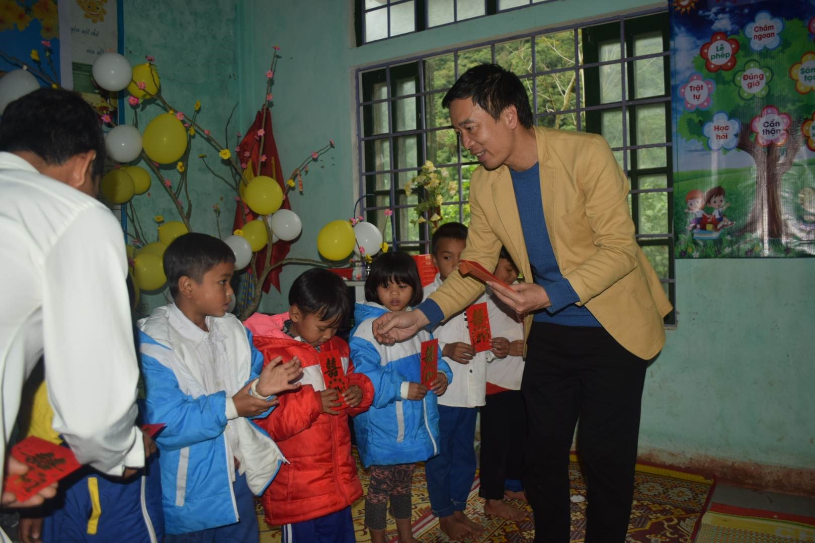Thầy Nguyễn Văn Tý, Hiệu trưởng nhà trường trao phong bao lì xì cho các em học sinh