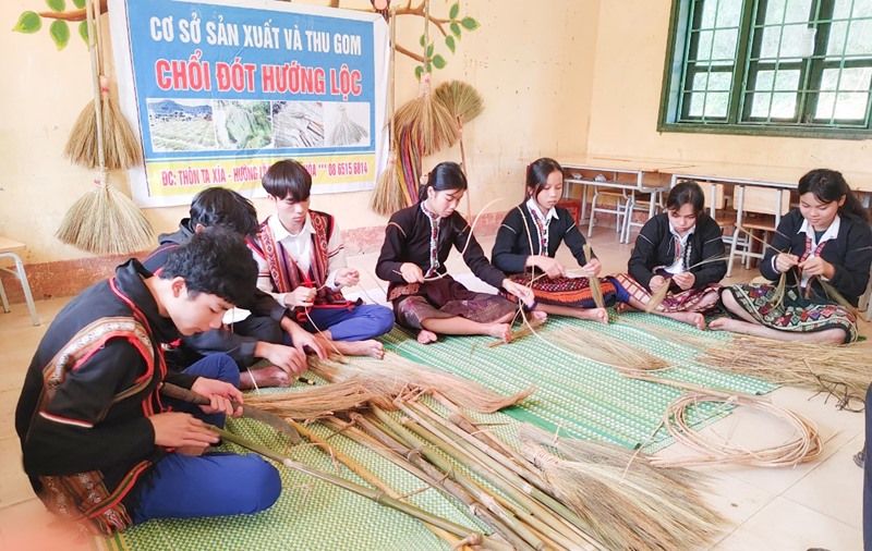 Học sinh Trường Phổ thông Dân tộc Bán trú Tiểu học và THCS Hướng Lộc tranh thủ đan chổi -Ảnh: B.L