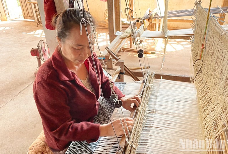 Một phụ nữ Lào đang dệt vải thủ công. (Ảnh: Hải Tiến)