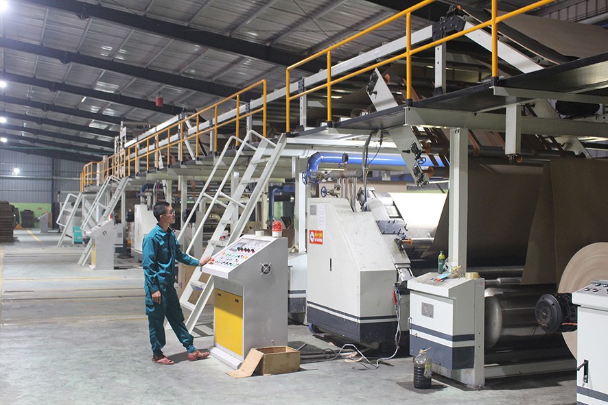 Công nhân vận hành hệ thống máy cắt chia khổ carton tự động tại Công ty Cổ phần Bao bì Carton Quảng Trị (Cụm công nghiệp Hải Lệ) - Ảnh: H.T
