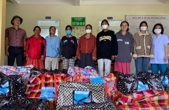 Thầy Phạm Minh Tuấn (ngoài cùng bên trái) trao đồ dùng thiết yếu đi sinh cho phụ nữ mang thai vùng đồng bào dân tộc thiểu số ở Hướng Hóa - Ảnh: KS