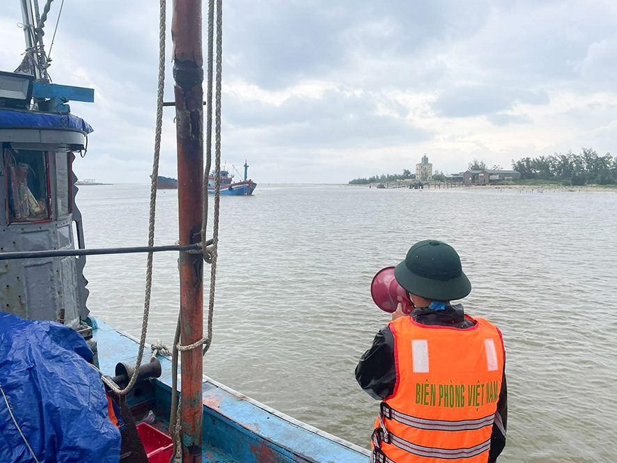 Cán bộ, chiến sĩ Đồn Biên phòng Triệu Vân tuyên truyền cho ngư dân đưa tàu thuyền vào nơi trú ẩn an toàn khi có mưa bão - Ảnh: X.T