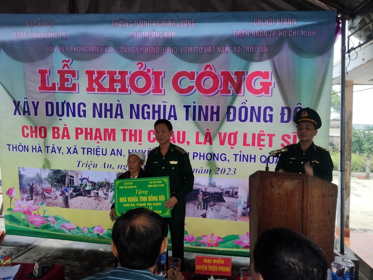 Đại tá Ngô Xuân Thường - Phó Chính ủy BĐBP tỉnh trao tặng biển tượng trưng ngôi nhà 100 triệu đồng cho Bà Phạm Thị Cháu - Vợ Liệt sĩ.