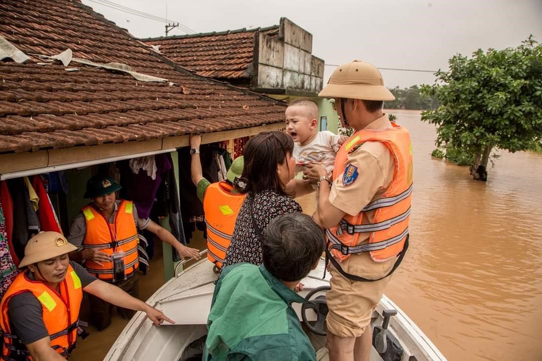 Lực lượng công an giúp dân trong bão lũ -Ảnh: TRẦN KHÔI