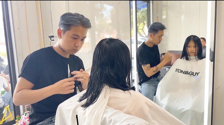 Anh Nguyễn Khương Nhật cắt tóc miễn phí cho khách hiến tặng tóc cho bệnh nhân ung thư - Ảnh: Đ.V