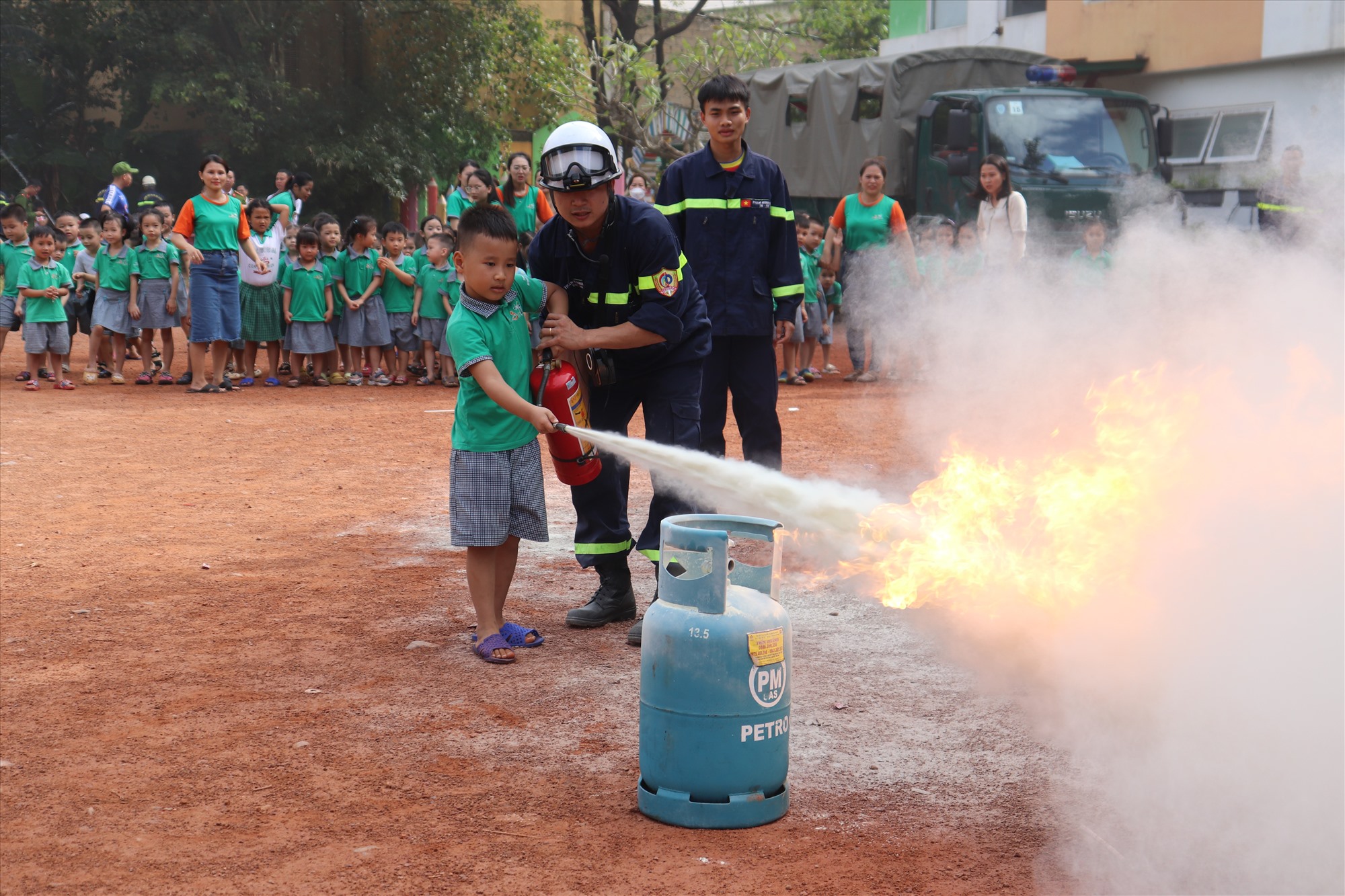 Học sinh Trường Mầm non iSmile được thực hành dập tắt đám cháy do rò rỉ khí gas - Ảnh: T.P