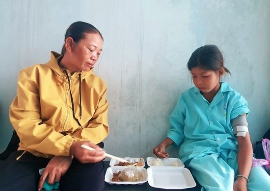 Lan Anh (bên phải) và mẹ san chia sẻ phần cơm bụi trong bệnh viện - Ảnh: TL
