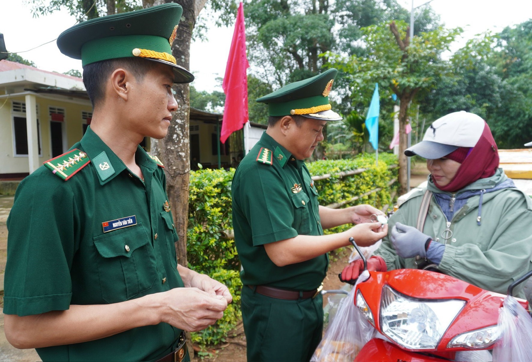 Cán bộ, chiến sĩ Đồn Biên phòng Hướng Lập trao tặng và hướng dẫn sử dụng “Móc khóa đường dây nóng” cho Nhân dân sống ở vùng biên -Ảnh: L.T