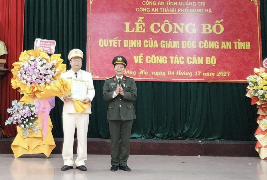 Đại tá Lê Phương Nam trao quyết định và tặng hoa chúc mừng Trung tá Ngô Nhật Tân - Ảnh: Anh Tuấn