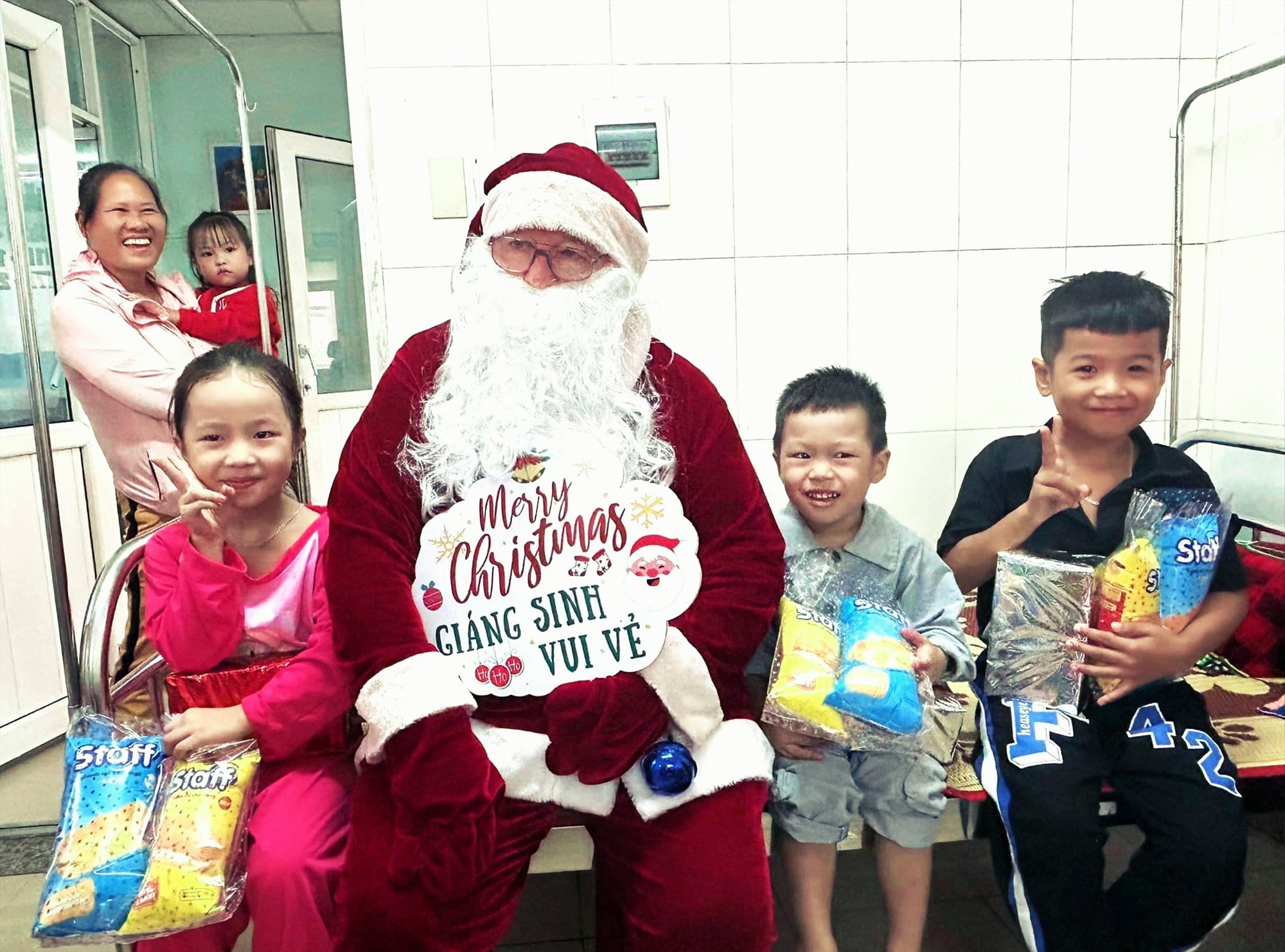 “Ông già Noel” Michael Gormalley tặng quà cho bệnh nhi ở Khoa Nhi, Bệnh viện Đa khoa tỉnh - Ảnh: BVĐK
