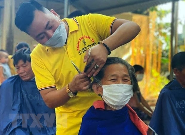 Anh Ngô Trọng Giáp cắt tỉa, căn chỉnh cẩn thận từng mái tóc cho bệnh nhân đang điều trị tại Bệnh viện Đa khoa huyện Triệu Phong. (Ảnh: TTXVN phát)