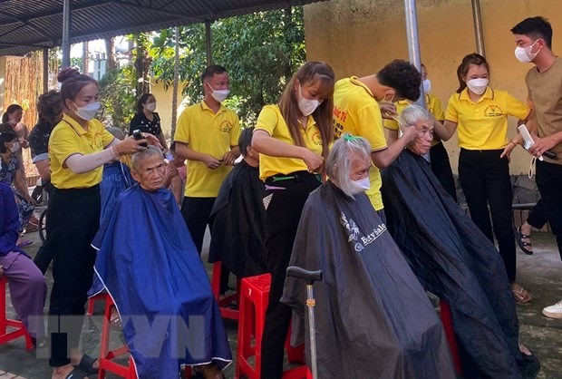 Cứ thứ 3 hàng tuần, anh Ngô Trọng Giáp cùng 6 nhân viên của mình tạm đóng cửa tiệm để tham gia cắt tóc miễn phí cho các bệnh nhân đang điều trị tại Bệnh viện Đa khoa huyện Triệu Phong. (Ảnh: TTXVN phát)