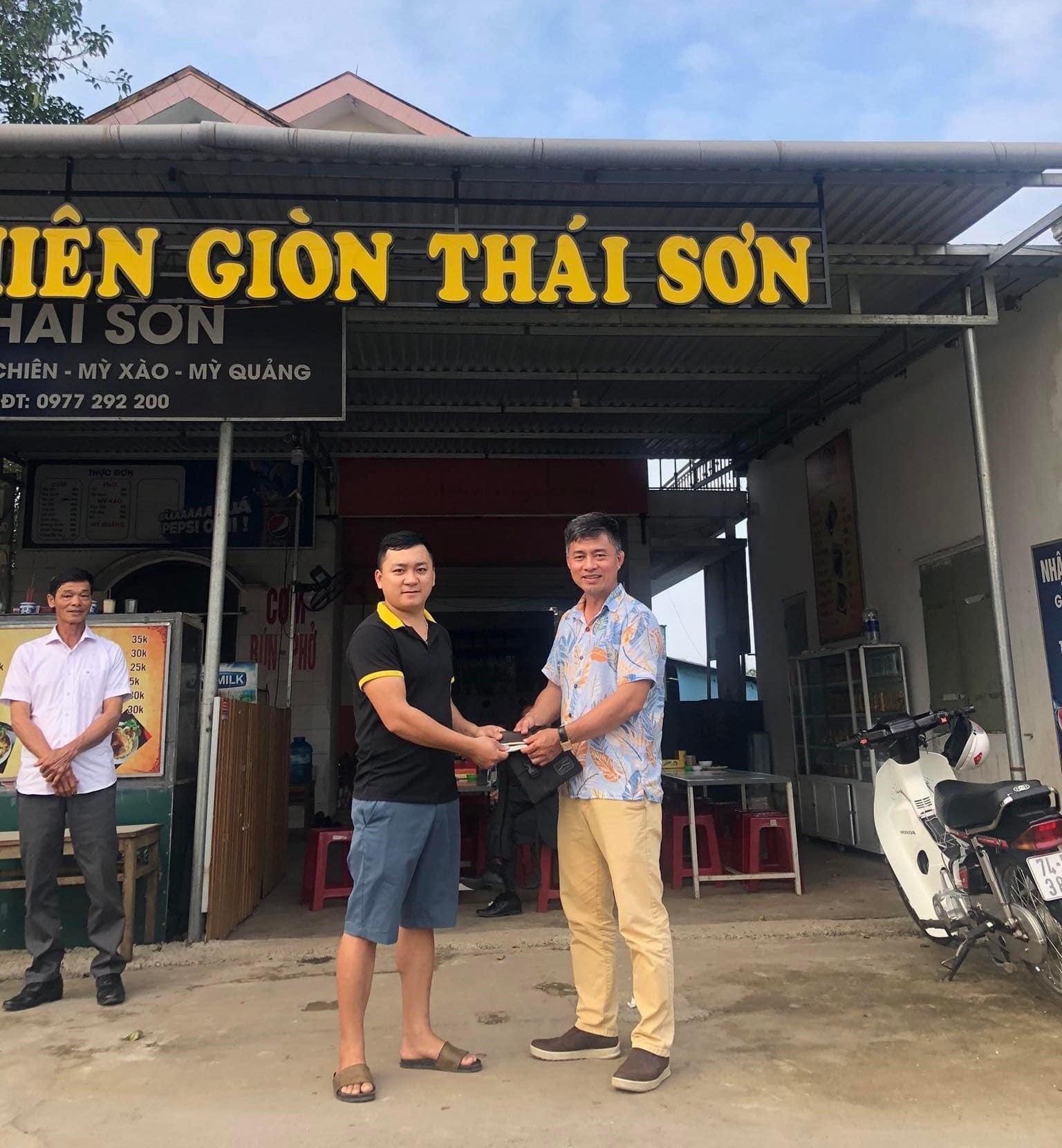 Anh Thái Tăng Sơn (áo đen), chủ quán cơm chiên giòn Thái Sơn trả lại chiếc túi cho khách hàng - Ảnh: NVCC