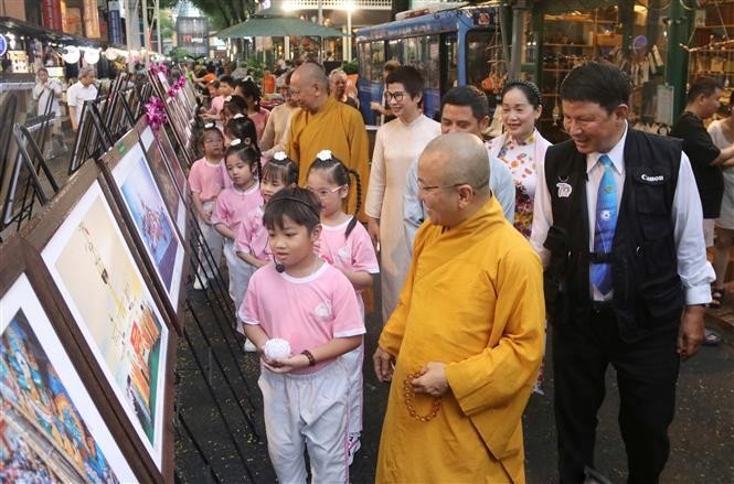 Đại biểu cùng các em nhỏ tham quan triển lãm.