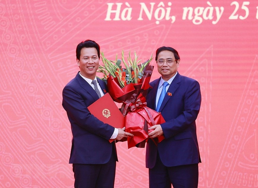 Thủ tướng Phạm Minh Chính chúc mừng Bộ trưởng Bộ Tài nguyên và Môi trường Đặng Quốc Khánh. (Ảnh: Dương Giang/TTXVN)