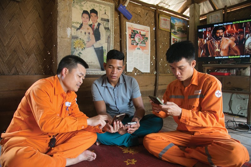 Anh Thái Tăng Đạo (bìa trái) hướng dẫn người dân ứng dụng công cụ chăm sóc khách hàng trên điện thoại thông minh - Ảnh: L.T