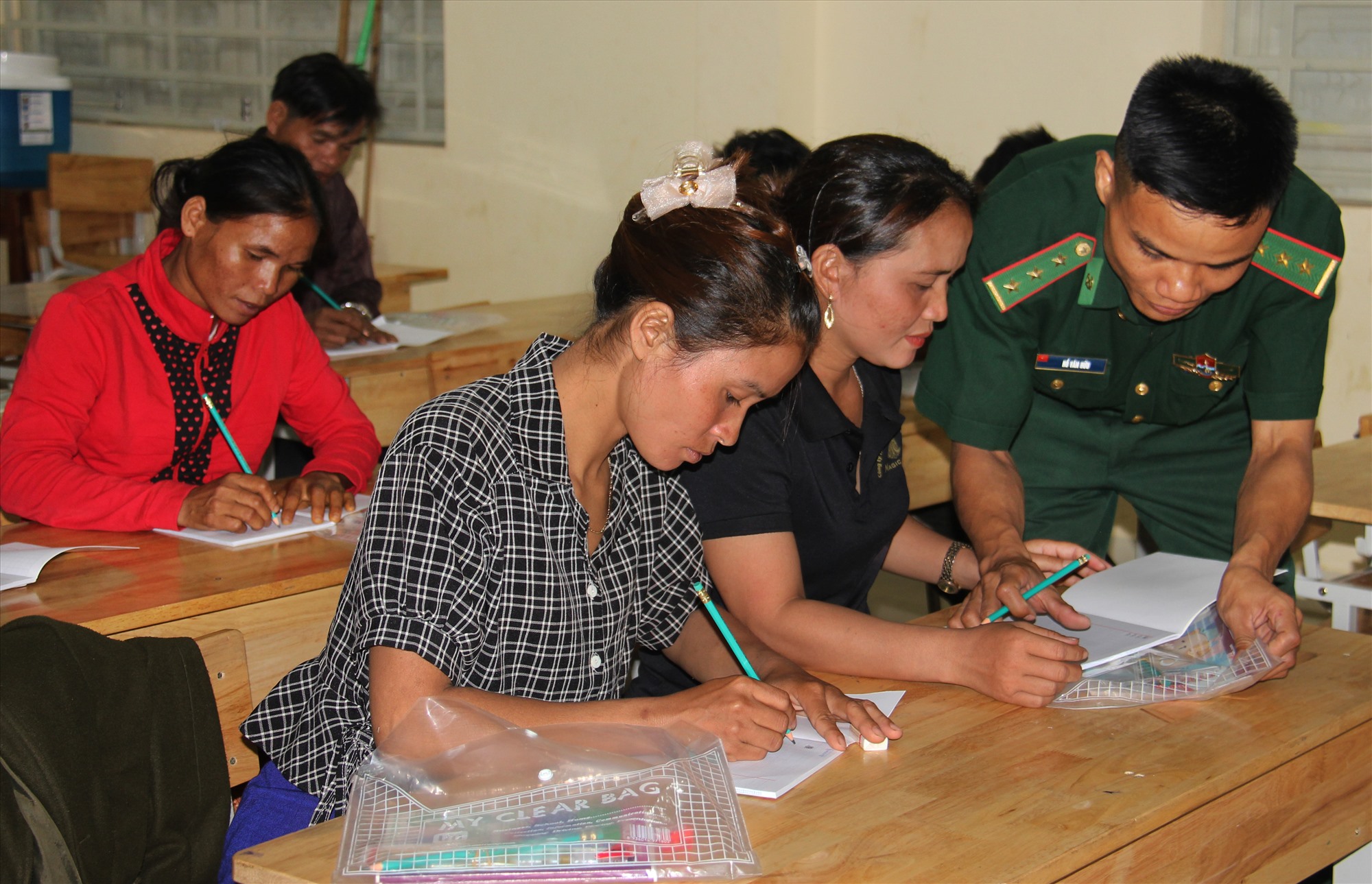 ! Thầy giáo Hồ Văn Hữu đang tập viết cho các chị ở lớp xoá mù tại điểm trường A Dơi Đớ, xã A Dơi, Hướng Hoá - Ảnh HỒ THANH THOAN (1)