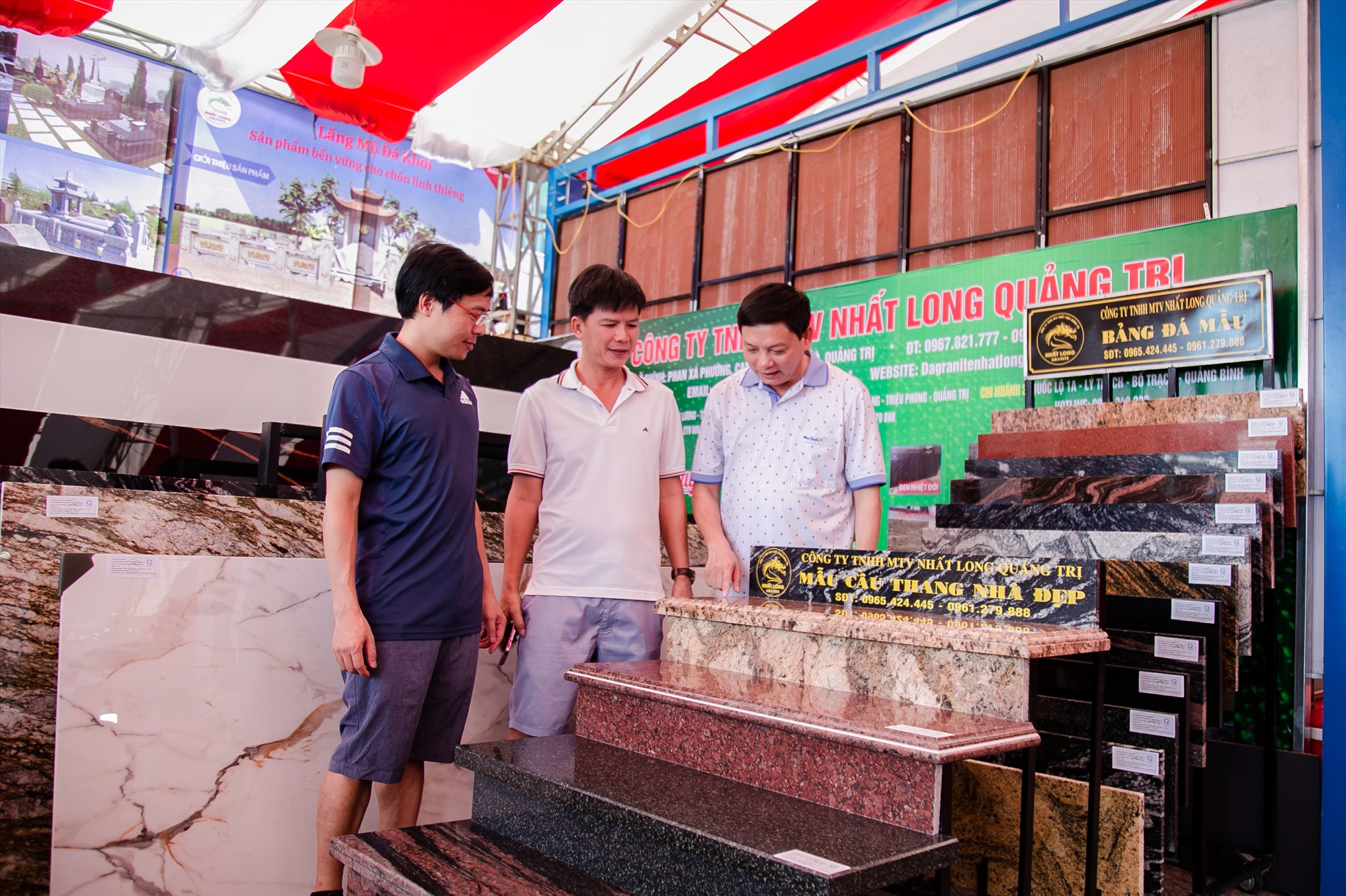 Anh Nguyễn Công Vương (ở giữa) tìm hiểu các mẫu đá granite của Công ty TNHH MTV Nhất Long Quảng Trị tại Hội chợ triển lãm trưng bày sản phẩm vật liệu xây dựng tỉnh Quảng Trị năm 2023 - Ảnh: Lê Trường