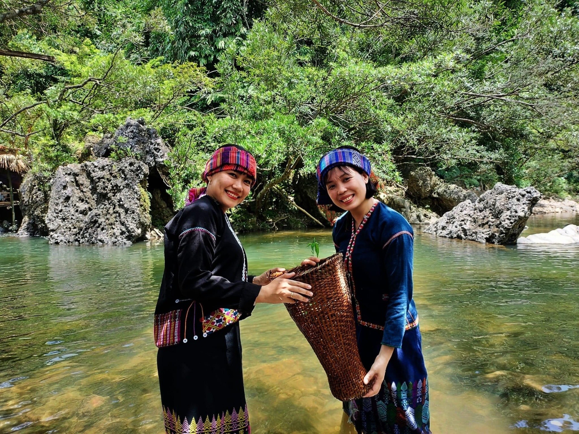 Du khách thích thú khi được trải nghiệm bắt cá suối trong bộ trang hục truyền thống người Vân Kiều ở điểm du lịch cộng đồng suối A Lao, xã Tà Long, huyện Đakrông.