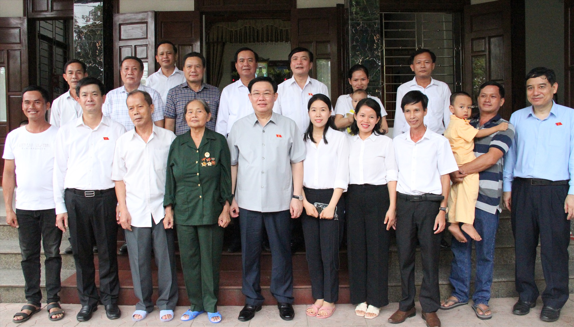 Chủ tịch Quốc hội Vương Đình Huệ và các thành viên đoàn công tác, lãnh đạo tỉnh chụp hình lưu niệm với gia đình bà Nguyễn Thị Phồn - Ảnh: MĐ