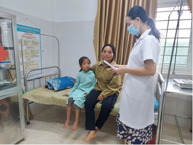 Bác sĩ Hồ Thị Hằng tận tình hướng dẫn đơn thuốc cho người nhà bệnh nhân - Ảnh: TYT xã Húc