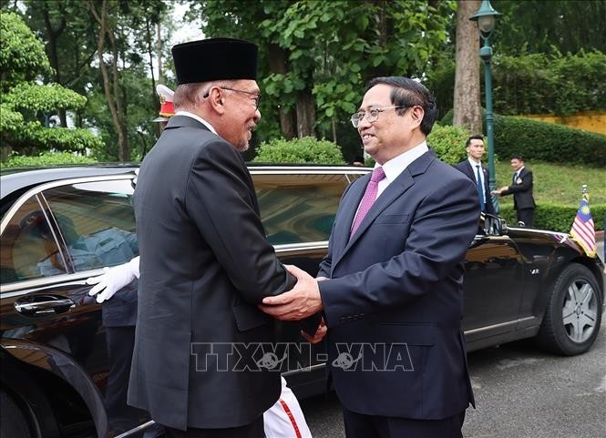Thủ tướng Phạm Minh Chính và Thủ tướng Malaysia Anwar Ibrahim duyệt Đội danh dự Quân đội nhân dân Việt Nam. Ảnh: Dương Giang/TTXVN