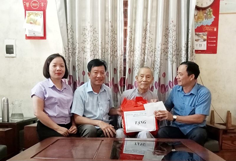 Lãnh đạo thị trấn Lao Bảo tặng quà cho cụ Lê Bá Huệ, con liệt sĩ ở khóm Tân Kim, thị trấn Lao Bảo - Ảnh: N.T.H