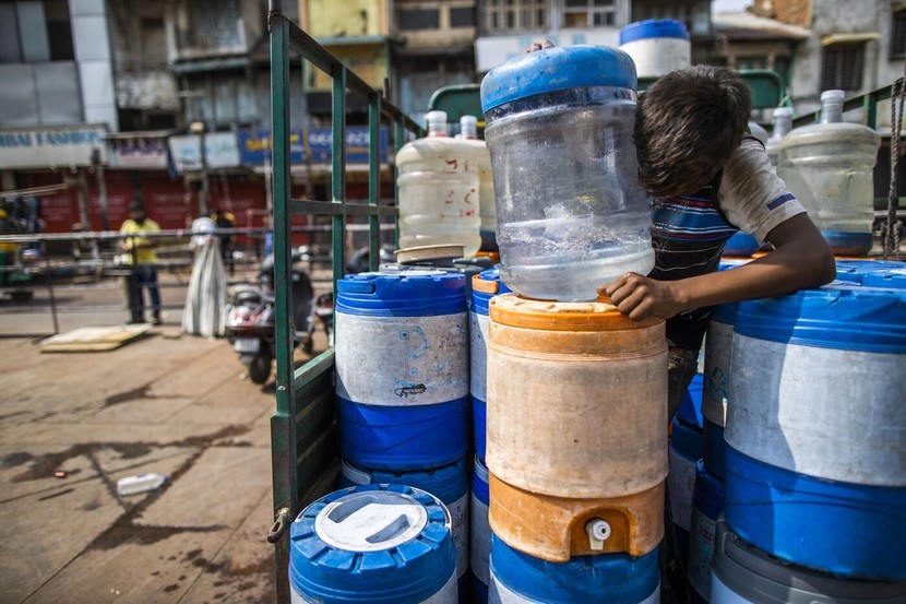 Một người đàn ông giao các thùng chứa nước ở Ấn Độ trong đợt nắng nóng năm nay. Ảnh: Bloomberg