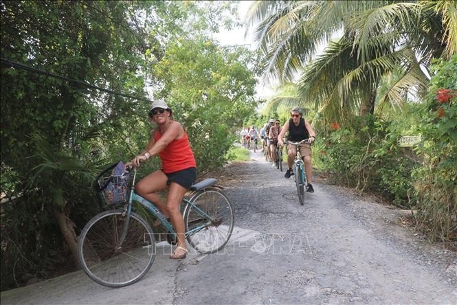 Du khách tham gia hoạt động đạp xe trên đường quê ở cù lao An Bình, huyện Long Hồ, tỉnh Vĩnh Long. Ảnh: Lê Thúy Hằng – TTXVN